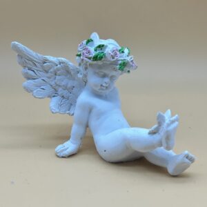 Angelito color blanco con corona de flores rosa sentado